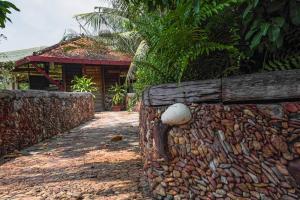 un mur en pierre à côté d'une maison dans l'établissement Veranda Natural Resort, à Kep