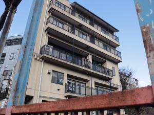 un edificio de apartamentos con balcones en un lateral en おばな旅館 富貴亭, 