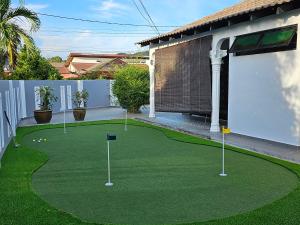 a putting green with golf balls and pins on it at Cosy Home + Mini Golf in Kuantan in Kuantan