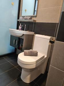 a bathroom with a white toilet and a sink at Cosy Home + Mini Golf in Kuantan in Kuantan