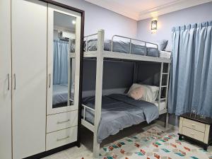 a bedroom with two bunk beds and a mirror at Cosy Home + Mini Golf in Kuantan in Kuantan