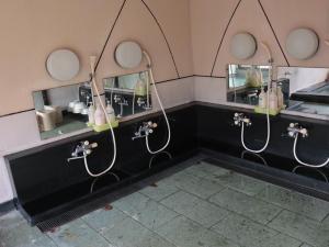 にあるおばな旅館 富貴亭の洗面台3つと鏡2つ付きのバスルーム