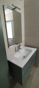 een badkamer met een witte wastafel en een spiegel bij Archidante in Bari
