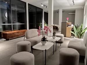 una sala de estar con sofás, sillas y flores en las mesas. en ONYX HOTEL & VILLA, en Tanjunguban