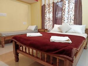 a bedroom with a large bed with towels on it at Samz estate stay 2BHK in Madikeri