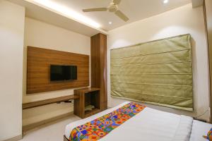 a bedroom with a bed and a flat screen tv at FabHotel Royal Palace II in Bhopal