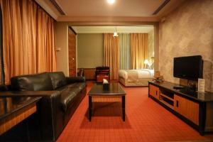 a living room with a leather couch and a bed at CREEK GATE HOTEL-BAITHANS in Sharjah