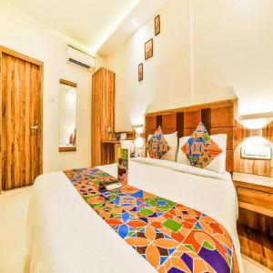 Cette chambre d'hôtel dispose d'un lit avec un couvre-lit coloré. dans l'établissement GATEWAY INN, à Mumbai