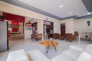 a living room with white furniture and a table at RedDoorz near Bojonegoro Train Station in Bojonegoro