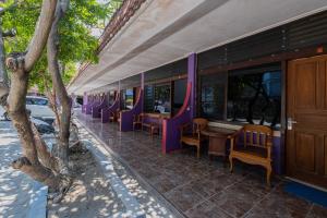 a train car with purple chairs and a table at RedDoorz near Bojonegoro Train Station in Bojonegoro