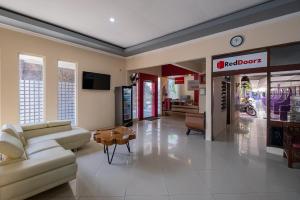 a living room with a couch and a table at RedDoorz near Bojonegoro Train Station in Bojonegoro