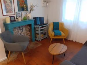 a living room with two chairs and a television at Maison chaleureuse près de lagrasse corbières in Saint-Pierre-des-Champs