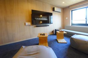 a hotel room with a couch and a tv at THE BONDS HOTEL TOKYO in Tokyo