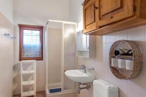 a bathroom with a sink and a toilet and a mirror at Casa Lara - Happy Rentals in Lugano