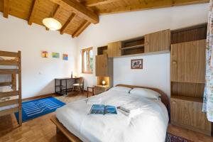 a bedroom with a large white bed with wooden cabinets at Casa Lara - Happy Rentals in Lugano