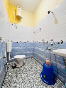 a bathroom with a toilet and penguins on the wall at SPM Residency, From Live2Travel Group. in Masinagudi