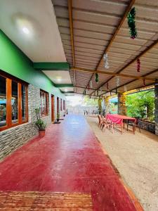 an empty corridor of a building with a table and benches at SPM Residency, From Live2Travel Group. in Masinagudi