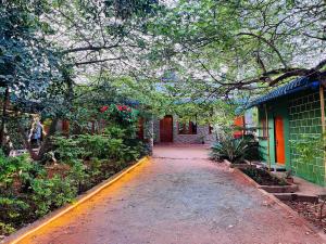 a walkway leading to a building with a tree at SPM Residency, From Live2Travel Group. in Masinagudi