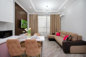 a living room with a couch and a table at Апартаменты бизнес-класса в ЖК Amir in Almaty