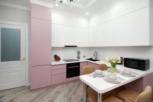 a pink kitchen with a table and chairs at Апартаменты бизнес-класса в ЖК Amir in Almaty