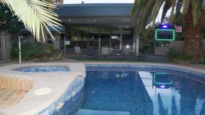 a swimming pool in front of a hotel at Golden Leaf Motel in Myrtleford