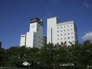 a large white building with a clock on it at Tottori City Hotel in Tottori