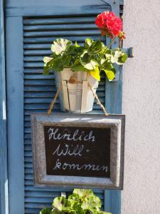 un cartello e una pianta in vaso su un muro di Dischhof a Biederbach Baden-Württemberg