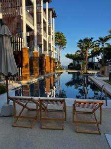 two chairs and an umbrella next to a pool at Vimanlay A302 - Happiness Elevated in Ban Bo Talung (2)