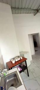 a kitchen with a sink and a table with a stove at Casa de campo en Bellavista in Puerto Ayora
