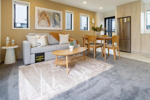 a living room with a couch and a table at New Brighton Beach Explore - King Bed and sofa bed in Christchurch