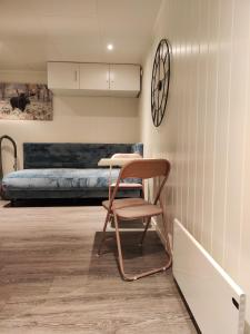 una sedia in una stanza con un letto e un orologio di Apartament 1 Havoysund a Havøysund