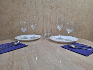 a table with four empty wine glasses and spoons at Аппартаменты 2 / х комнатная in Ustʼ-Kamenogorsk