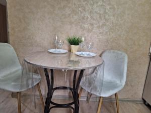 un tavolo con bicchieri da vino e una pianta in vaso di Аппартаменты 2 / х комнатная a Öskemen