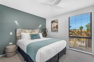 - une chambre avec un grand lit et une fenêtre dans l'établissement Tasman Holiday Parks - Papamoa Beach, à Papamoa