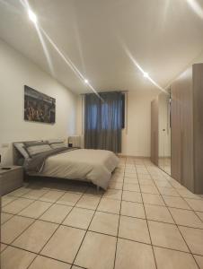 a bedroom with a bed and a tiled floor at Appartamento c&y Monte san Gabriele in Novara