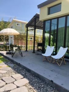 two chairs and an umbrella on a patio at Yangyang, Stay There in Yangyang