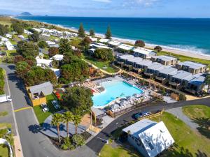 an aerial view of a resort with a pool and the ocean at Tasman Holiday Parks - Papamoa Beach in Papamoa