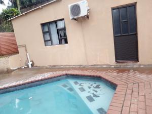 a swimming pool in front of a house at Rato Thato Guest House in Durban
