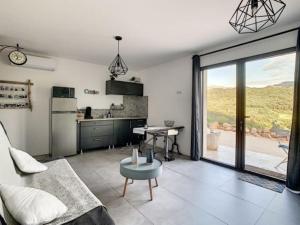 a living room with a couch and a kitchen at Studio entre mer et montagne in Ocana