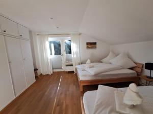 a bedroom with two beds and a large window at Ferienwohnung Erika in Oberstdorf