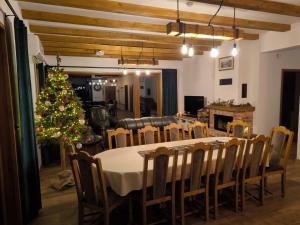 a dining room with a table and a christmas tree at Mazurski Horyzont in Leleszki