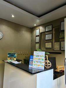 a counter in a office with a clock on the wall at Seaslugs Traveller's Inn in El Nido