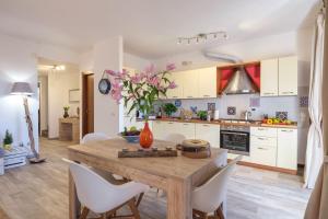 a kitchen with a wooden table and white cabinets at La Luna nel Lago Lake View Garden - Happy Rentals in Ispra