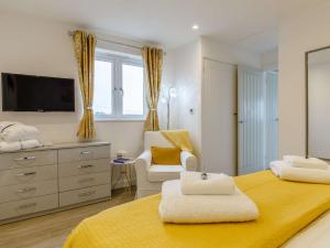 1 dormitorio con 1 cama, 1 silla y TV en 1 Bed in Sennen 85566 en St Just