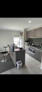 a large kitchen with a counter and a table at Cosy Room with lock and work area in Truganina