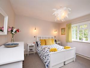 sypialnia z białym łóżkiem z żółtymi poduszkami w obiekcie 3 Bed in Branscombe 78002 w mieście Branscombe