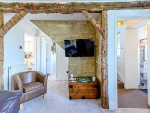 een woonkamer met een tv aan een bakstenen muur bij 3 Bed in Corfe Castle 78831 in Corfe Castle