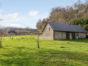 un antiguo granero de piedra en un campo con ovejas en 2 Bed in Tisbury 78165, en Tisbury