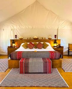 ジャイサルメールにあるLuxury The Sunrise Resort with swimming pool Jaisalmerのテント内のベッド1台(ベッドルーム内、ラグ2枚付)