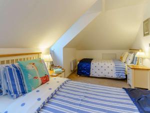 a attic bedroom with two beds in a room at 3 Bed in Tenby FB273 in Tenby